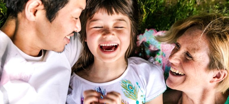 family laughing in grass